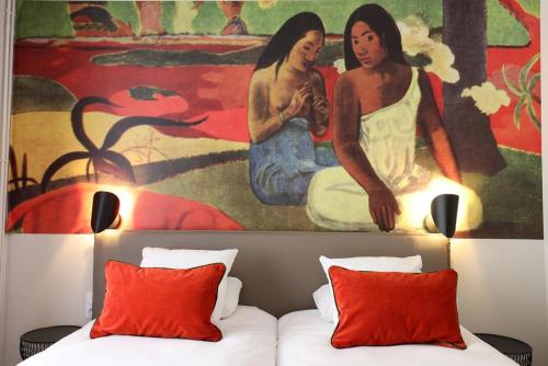 a bedroom with a painting above a bed with red pillows at Hôtel la Capelle Millau in Millau