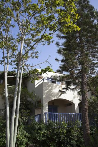 a white house with trees in front of it at Elpida Village in Istron