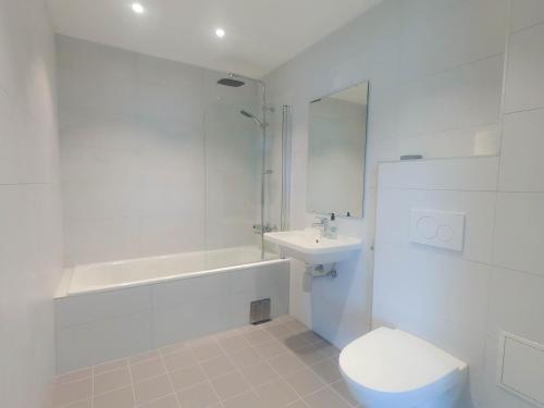 a white bathroom with a toilet and a sink at Fjordgaarden Mo in Mo i Rana