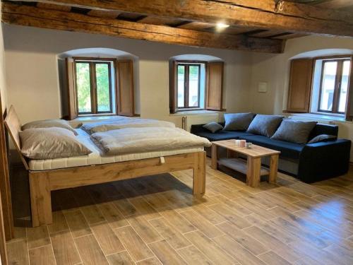 sypialnia z dużym łóżkiem i kanapą w obiekcie Apartmány Kurojedy w mieście Bor