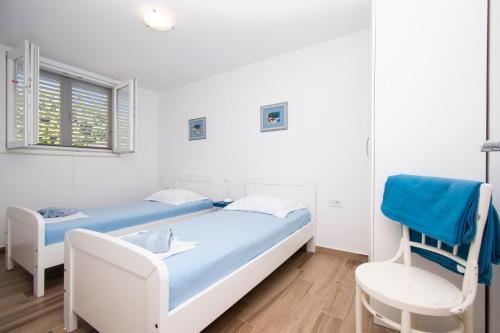 a hospital room with two beds and a chair at Holiday Home Ivana in Brodarica