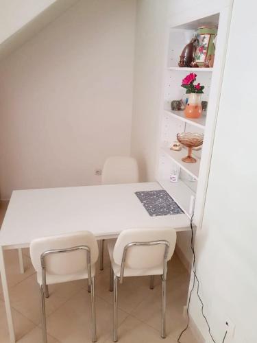 a kitchen with a white table and two chairs at Apartment Dalma in Podgora