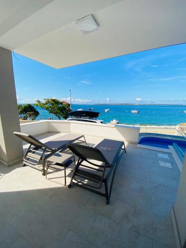 a balcony with a table and chairs and the ocean at Villa Mondee in Mandre