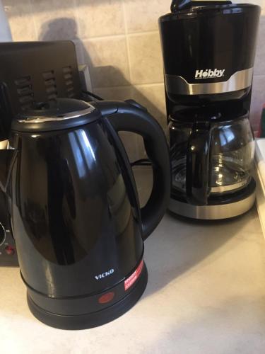 a black coffee maker and a coffeemaker on a counter at John's apartment's near Athens Airport!! in Spáta