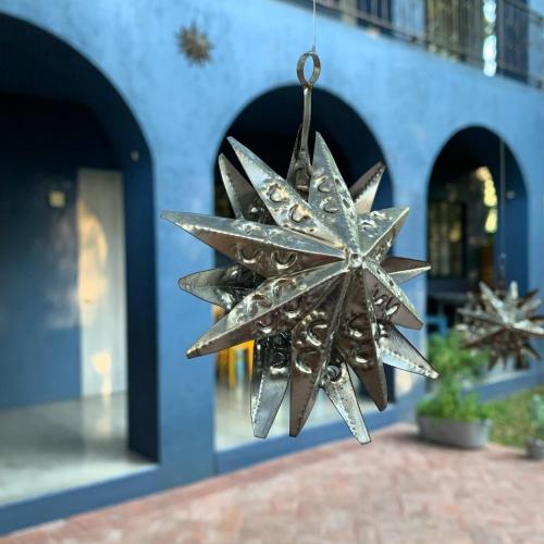 a metal snowflake hanging from the side of a building at La Betulia Bed and Breakfast in Oaxaca City
