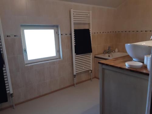 a bathroom with a sink and a window at Le Moulin du Cluzeau in Chaillac