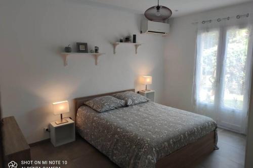 a bedroom with a bed with two lamps on it at Villa Katiramona in Le Muy