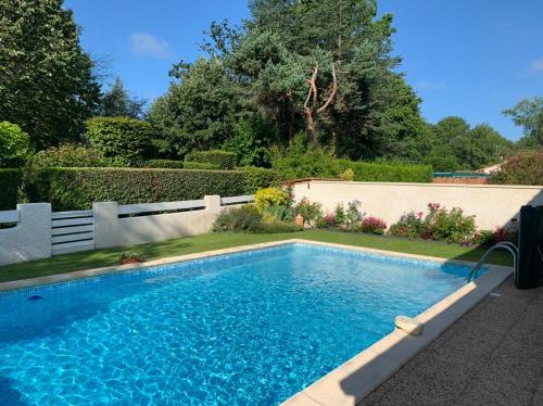 a swimming pool in a yard next to a fence at Maison ruisseau l'eau blanche in Léognan