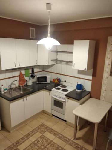 uma cozinha com armários brancos e um forno com placa de fogão em 1к. Апартаменты НСК , на Блюхера 71б. em Novosibirsk