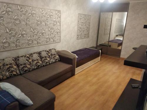 uma sala de estar com um sofá e um espelho em 1к. Апартаменты НСК , на Блюхера 71б. em Novosibirsk