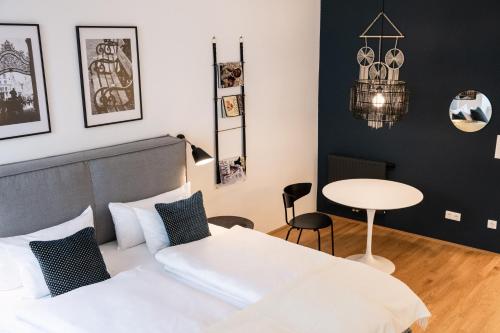 um quarto com uma cama branca e uma mesa em The BL42 - Vienna Concept Apartments em Viena