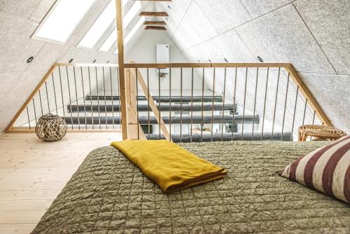 a bed with a yellow blanket on it in a room at Ferielejlighed Holmevej in Næstved