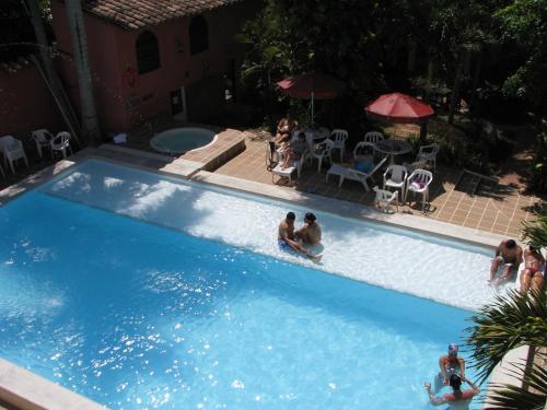 a group of people sitting in a swimming pool at Casa Hotel Guaracú in Santa Fe de Antioquia