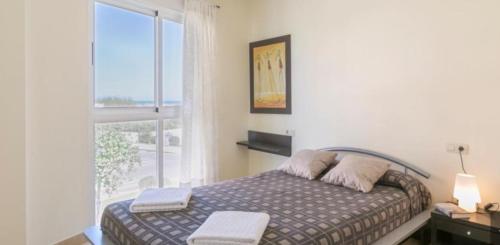 1 dormitorio con cama y ventana grande en Aguamarina Golf 3, en Oliva
