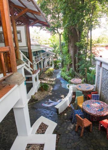 a patio with tables and chairs and trees at Oceanfront Hotel Verde Mar direct access to the beach in Manuel Antonio