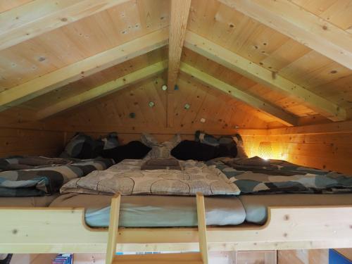 a room with three beds in a wooden ceiling at Tiny Sport base in Innsbruck