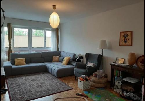 a living room with a blue couch and a chair at Appartement pour 2/3personnes in Neuvecelle
