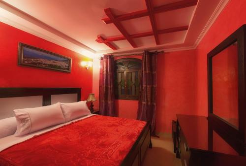 a bedroom with red walls and a bed in it at Résidence Hoteliére Chez Aziz in Chefchaouene