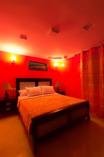 a bedroom with red walls and a large bed at Résidence Hoteliére Chez Aziz in Chefchaouene