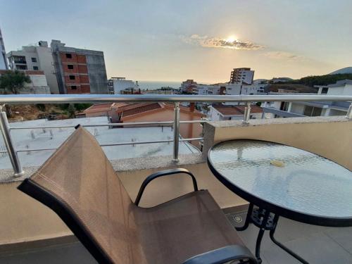 a table and chair on a balcony with a view of a city at Fimi Apartments in Ulcinj