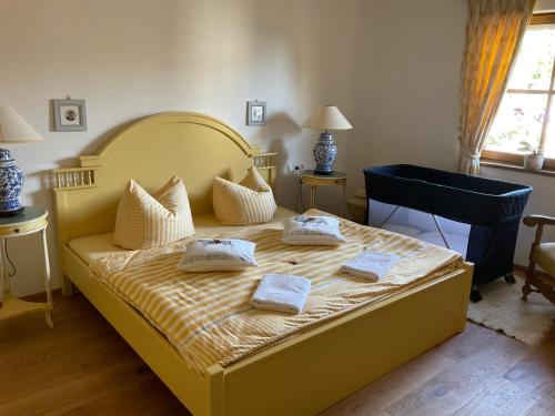 een slaapkamer met een geel bed met 2 kussens erop bij Szilvias Ferienwohnung in Tittling