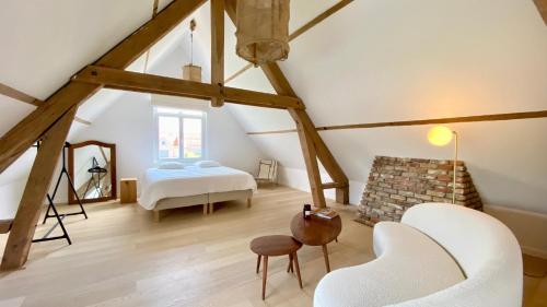 a attic room with a bed and a fireplace at House C in De Haan