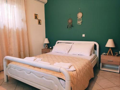 1 dormitorio con cama y pared verde en Villy's apartment, en Nauplia