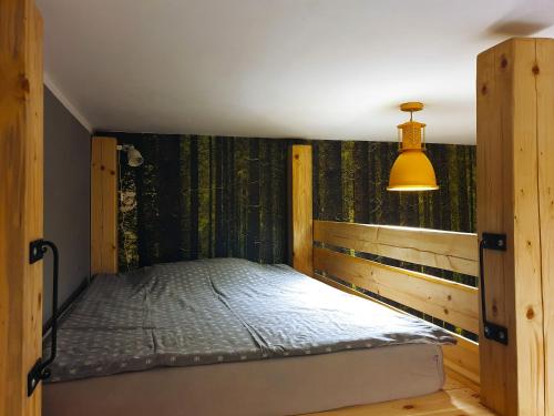 Un dormitorio con una cama en la esquina con una lámpara en Industrium, en Stronie Śląskie