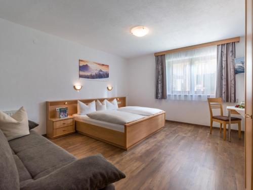 a bedroom with a bed and a couch at Landhaus Kröll in Hippach