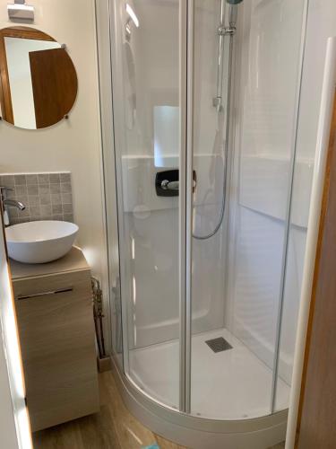 a shower with a glass door in a bathroom at Le paradis des oiseaux in Saint-Gildas