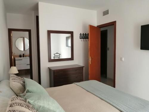 1 dormitorio con cama, espejo y lavamanos en Bonita casa con piscina privada, en Villafranca de Córdoba
