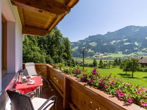 a balcony with a table and chairs and flowers at Landhaus Kröll in Hippach