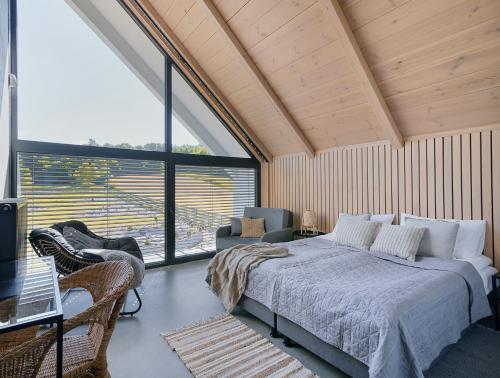 a bedroom with a bed and a large window at Przystanek Guciów in Guciów