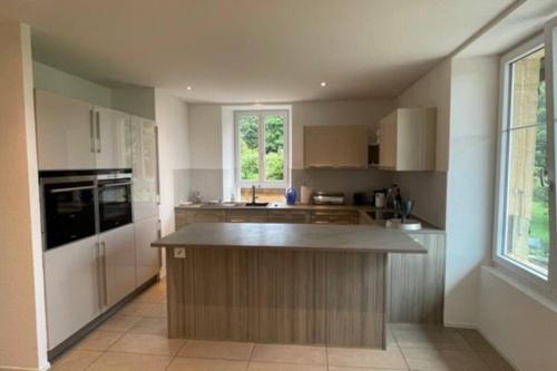 a kitchen with a island in the middle of it at Vöens, St-Blaise, Logement entier - 2 chambres in Marin