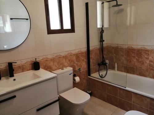 y baño con aseo, lavabo y espejo. en Bonita casa con piscina privada, en Villafranca de Córdoba