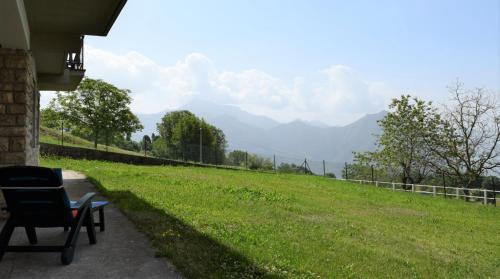 a chair sitting on a porch with a view of a field at Il Roseto Mountain Lake Iseo Hospitality in Bossico