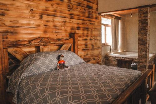 un dormitorio con una cama con una muñeca sentada en ella en Cabaña Luna, en Mazamitla