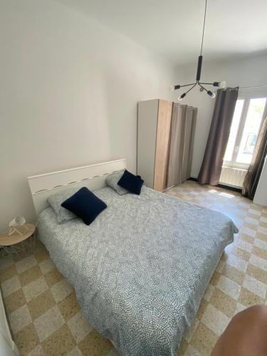 een slaapkamer met een bed met blauwe kussens erop bij Maisonnette Cagnes in Cagnes-sur-Mer