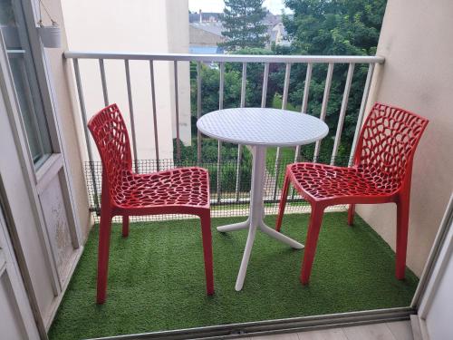 two chairs and a table on a balcony at Studio bien équipé, situé en hyper centre in Vendôme