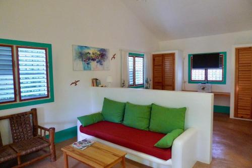 a living room with a red and green couch at Apart-Hotel Garden Villa in Las Galeras
