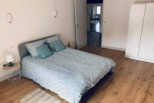 sypialnia z łóżkiem z niebieskimi poduszkami w obiekcie Charmant appartement T2 hypercentre de Mazamet w mieście Mazamet