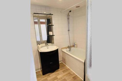 La salle de bains est pourvue d'une baignoire, d'un lavabo et d'une baignoire. dans l'établissement Charmant appartement T2 hypercentre de Mazamet, à Mazamet