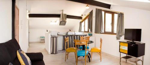 sala de estar con cocina, mesa y sillas en Apartamentos Puenteviejo, en Arenas de San Pedro