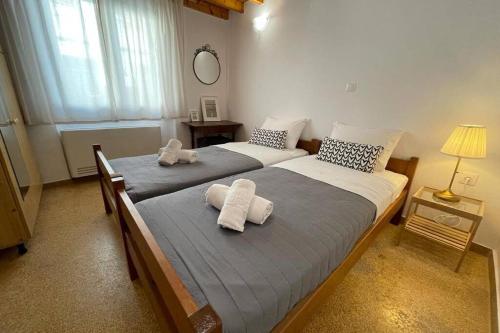 - 2 lits dans une chambre avec des serviettes dans l'établissement PANOS ROOMS Modern 3-Bedroom apartment, à Andros