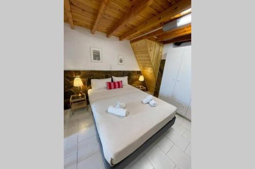 een slaapkamer met een bed met twee handdoeken erop bij PANOS ROOMS Beachfront apartment with Loft in Ándros