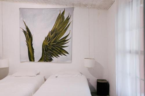 twee bedden in een kamer met een schilderij aan de muur bij Casa Crudo, PRIVACIDADE NA MATA ATLÂNTICA, piscina, trilhas e descanso in Salesópolis