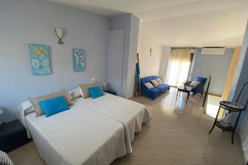 een slaapkamer met een groot bed en een blauwe stoel bij Casa del Garcelan in Orba