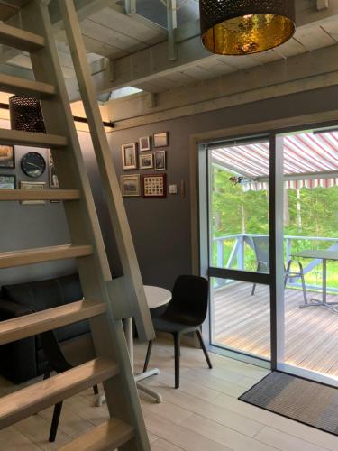 a room with a staircase and a table and a balcony at Putnu pirts in Saulkrasti