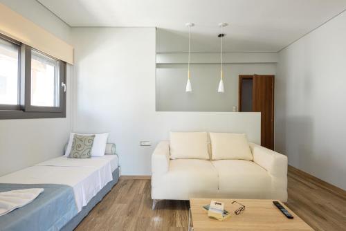 a bedroom with a bed and a couch at Regos Resort Hotel in Neos Marmaras