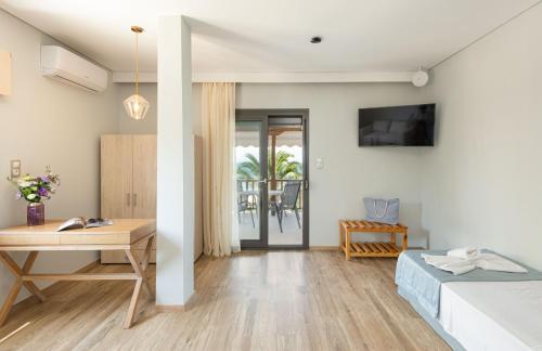 a bedroom with a bed and a desk and a table at Regos Resort Hotel in Neos Marmaras